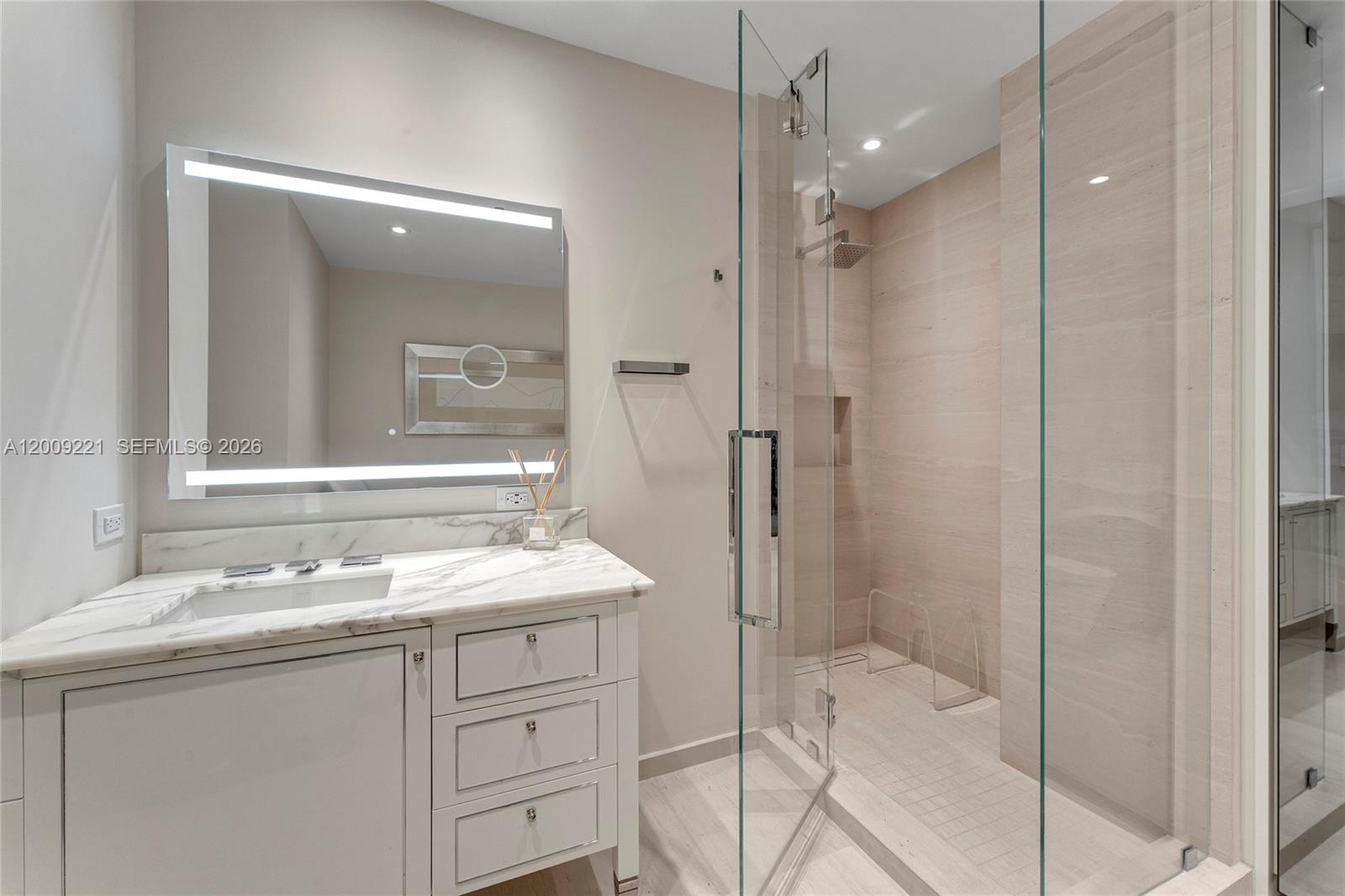 9349 Collins Avenue, Unit 801 Surfside, FL 33154 - Photo 34 of 59 a bathroom with a shower sink vanity granite and a mirror