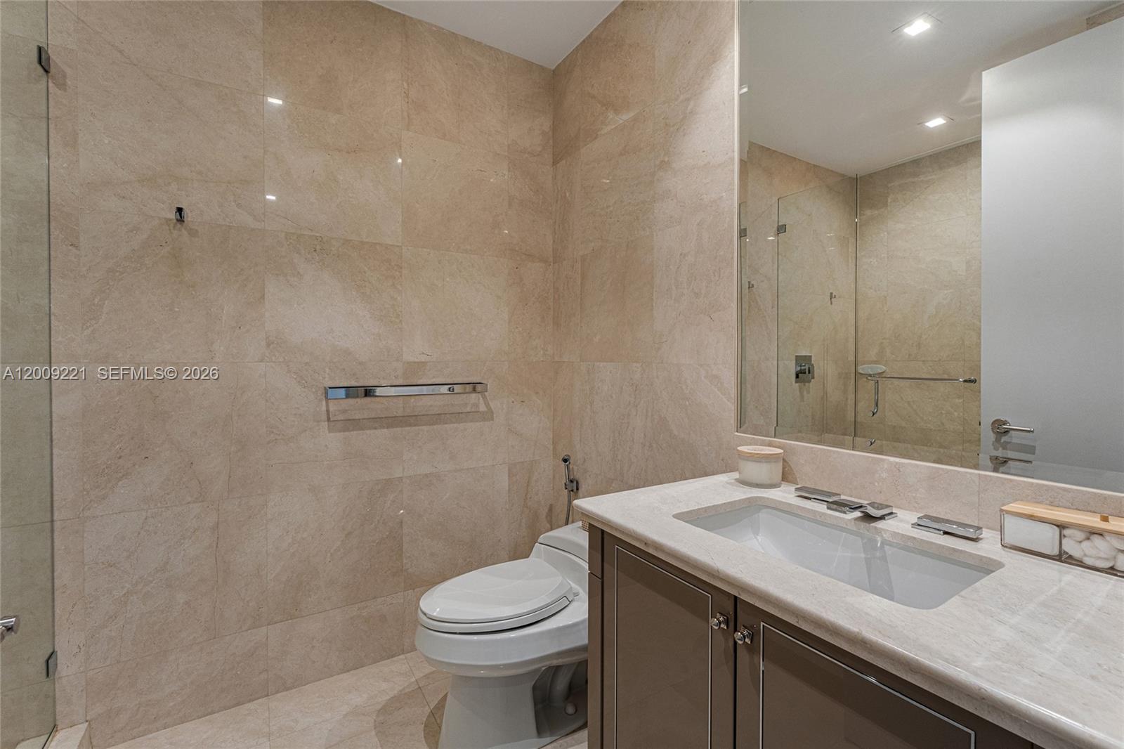 9349 Collins Avenue, Unit 801 Surfside, FL 33154 - Photo 44 of 59 a bathroom with a sink a toilet and shower