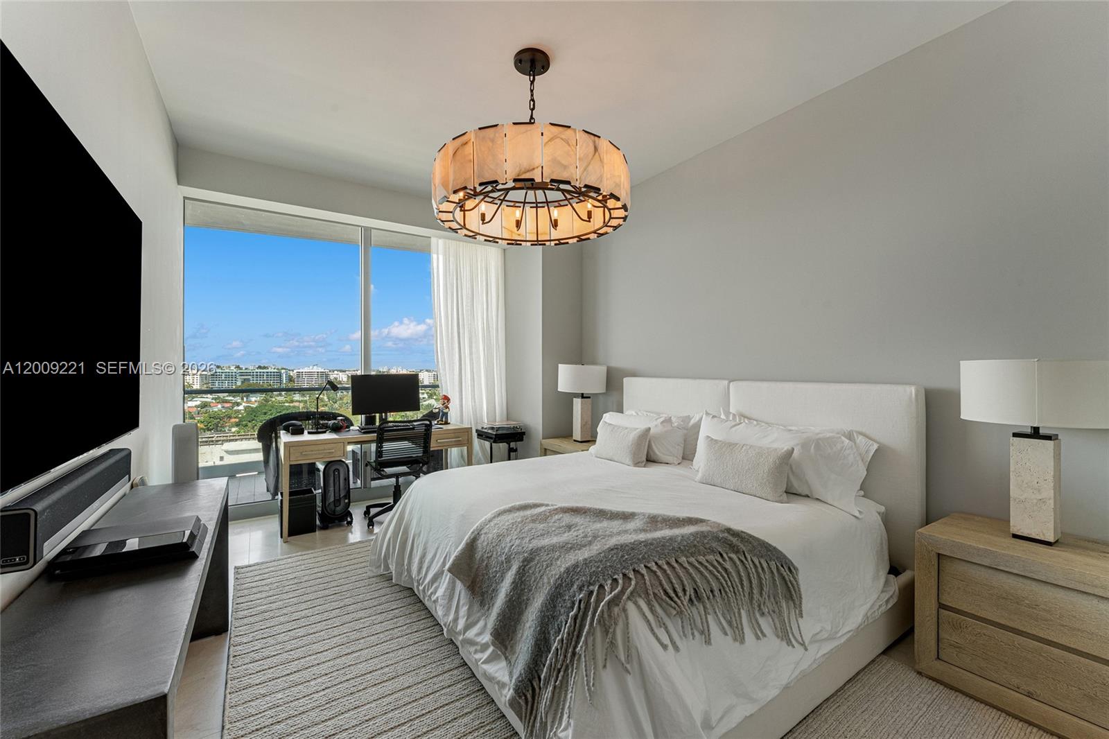 9349 Collins Avenue, Unit 801 Surfside, FL 33154 - Photo 47 of 59 a bedroom with bed and a chandelier