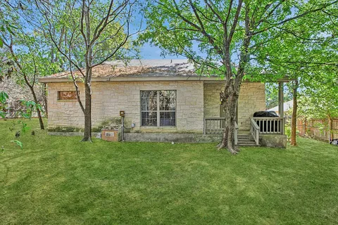 a view of a house with backyard and a tree