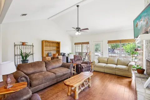 a living room with furniture ceiling fan and a large window