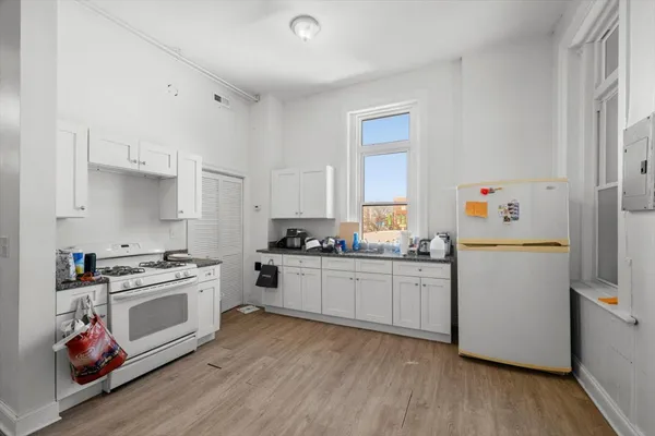 a kitchen with sink a stove and white cabinets