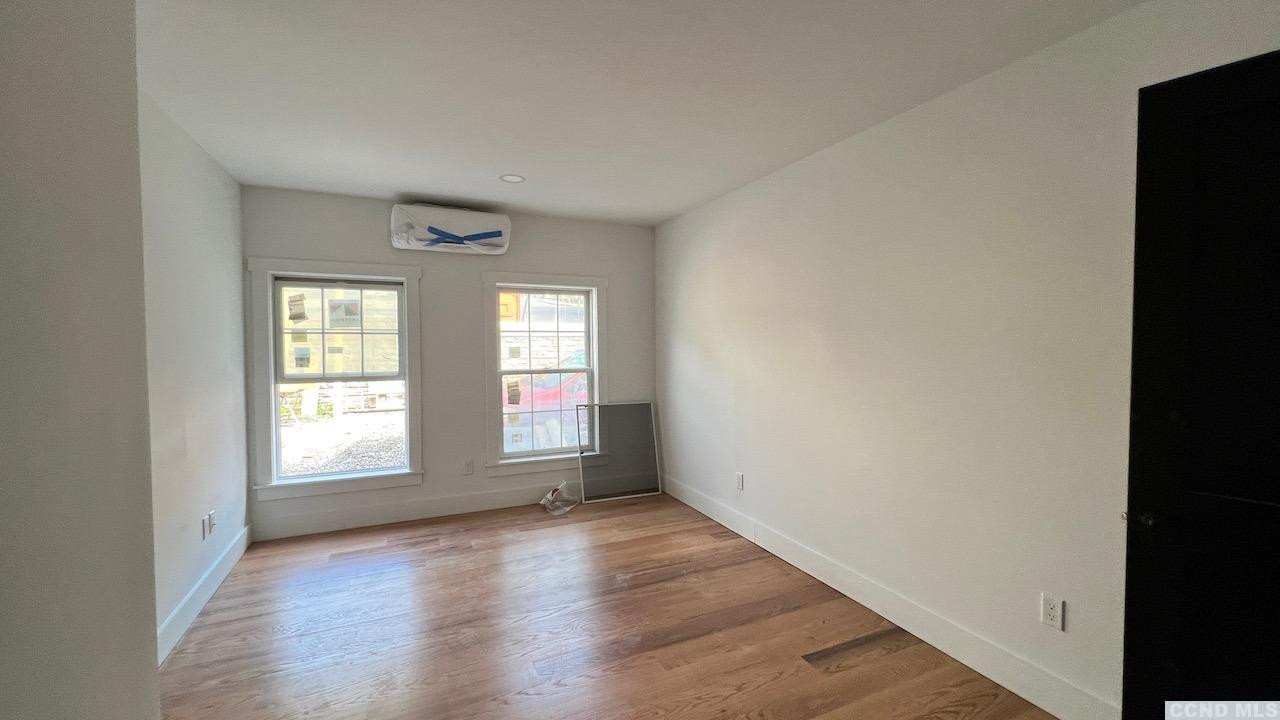 406 Main Street, Unit 2E Catskill, NY 12414 - Photo 11 of 28 an empty room with wooden floor and windows