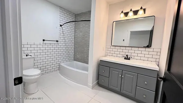 a bathroom with a sink toilet and mirror