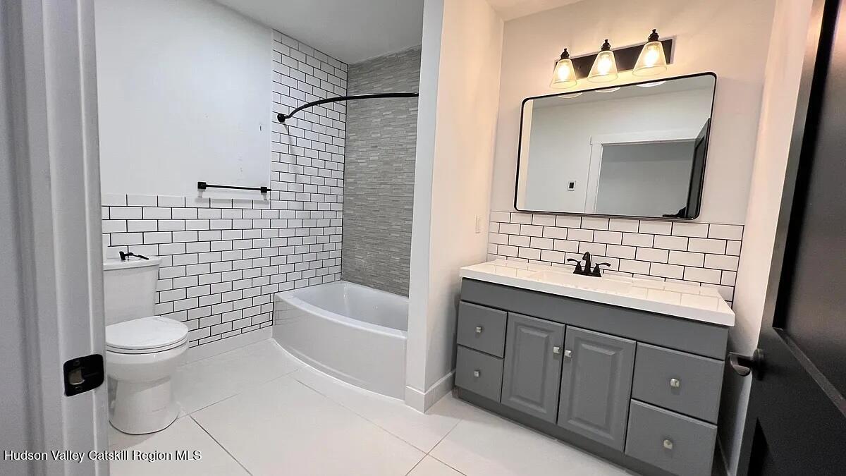 406 Main Street, Unit 2E Catskill, NY 12414 - Photo 19 of 28 a bathroom with a sink toilet and mirror