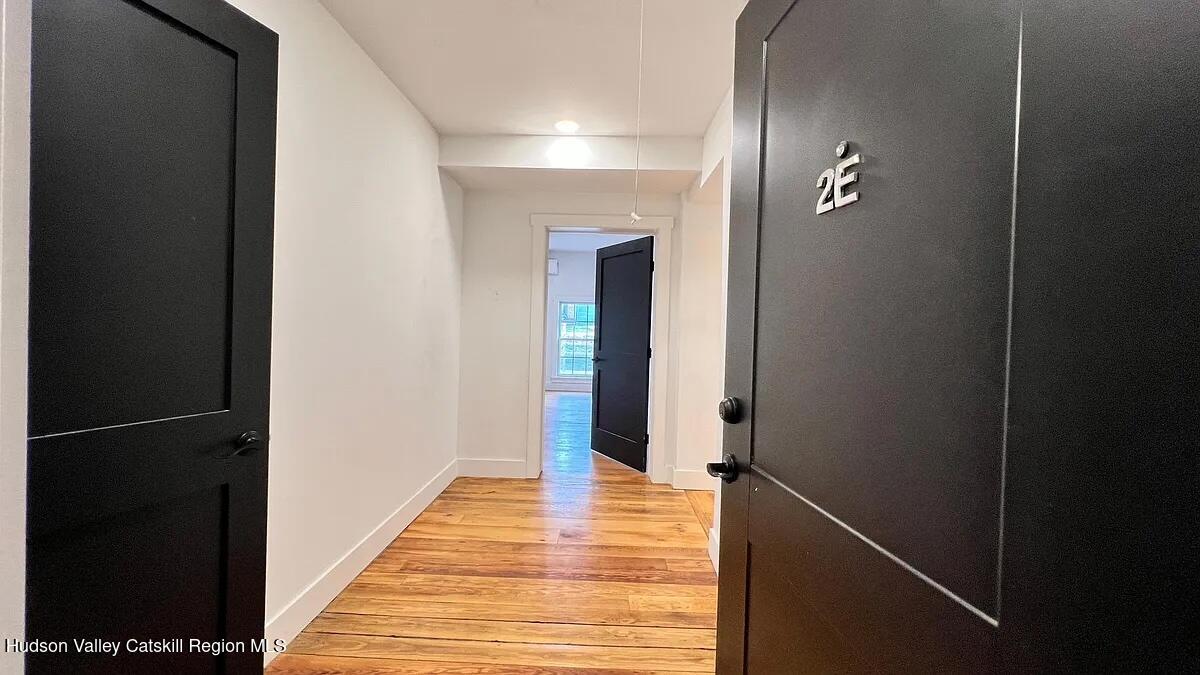 406 Main Street, Unit 2E Catskill, NY 12414 - Photo 2 of 28 a view of a hallway with wooden floor and staircase