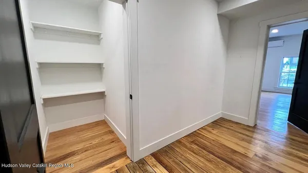 a view of empty room with wooden floor