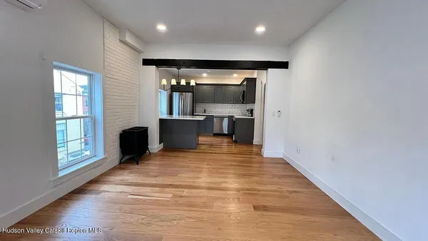 a view of empty room with wooden floor and fireplace