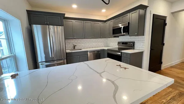 a kitchen with stainless steel appliances a refrigerator stove microwave and sink