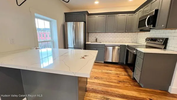 a kitchen with stainless steel appliances a refrigerator a sink a stove and cabinets