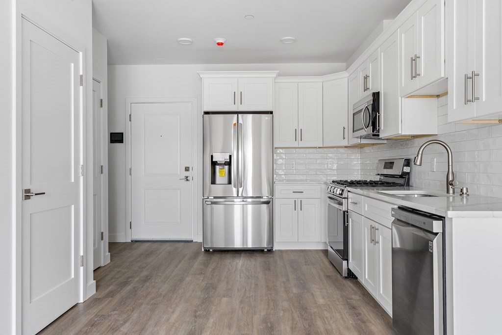 1133 North Shore Road, Unit 205 Revere, MA 02151 - Photo 4 of 20 a kitchen with stainless steel appliances a refrigerator stove and sink