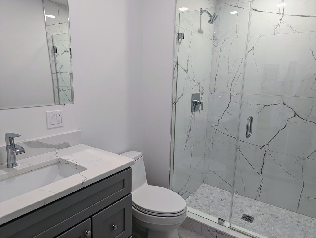 1133 North Shore Road, Unit 205 Revere, MA 02151 - Photo 5 of 20 a bathroom with a sink a toilet and shower