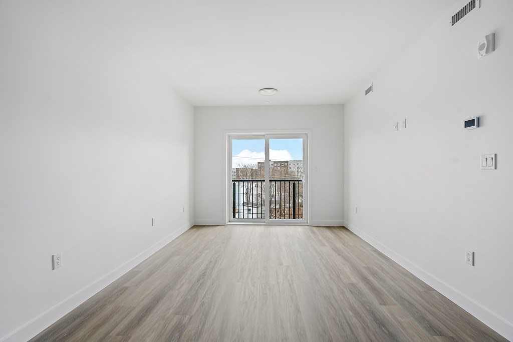 1133 North Shore Road, Unit 205 Revere, MA 02151 - Photo 8 of 20 wooden floor in an empty room with a window