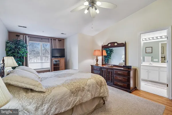 a bedroom with a bed and dresser with mirror
