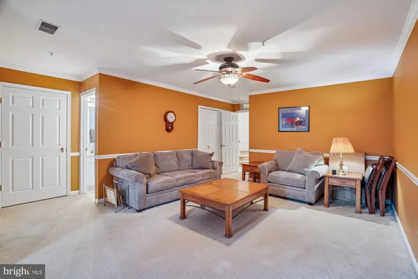 a living room with furniture a ceiling fan and a window
