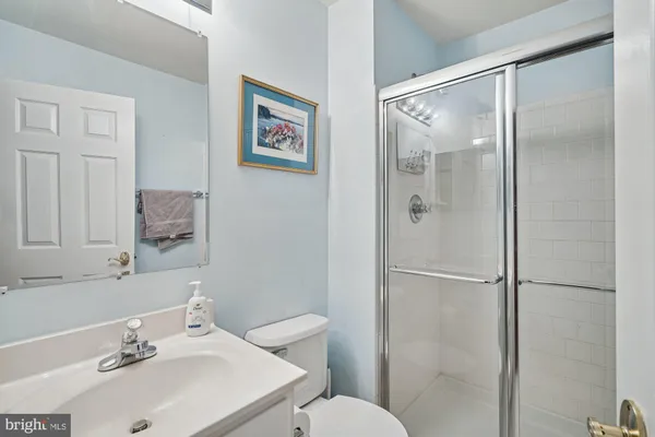 a bathroom with a sink mirror and a toilet