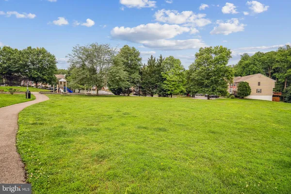 a view of a green field with trees in the background