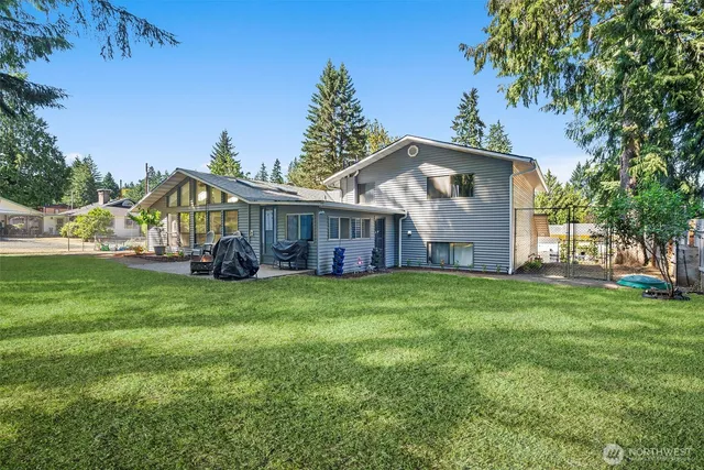 a view of a house with a big yard potted plants and large tree