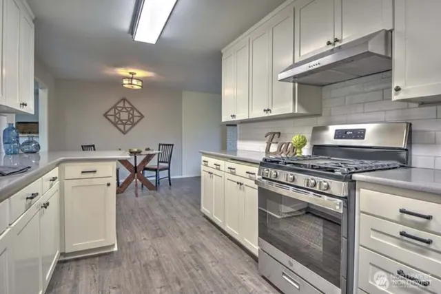 a kitchen with a stove and white cabinets
