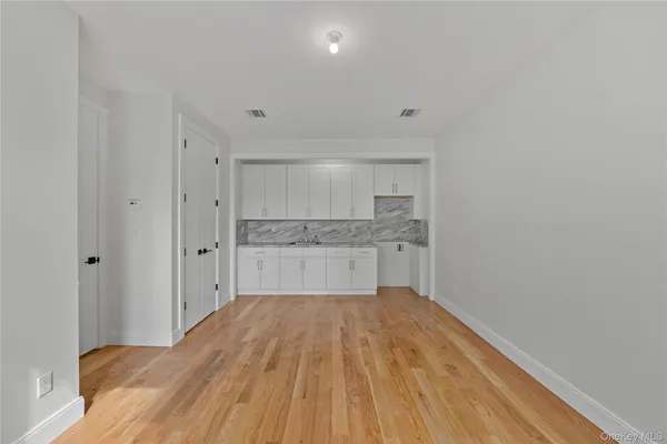 a view of a kitchen with a sink and wooden floor