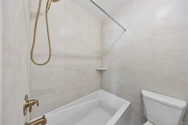 a bathroom with a bath tub with a toilet next to a shower