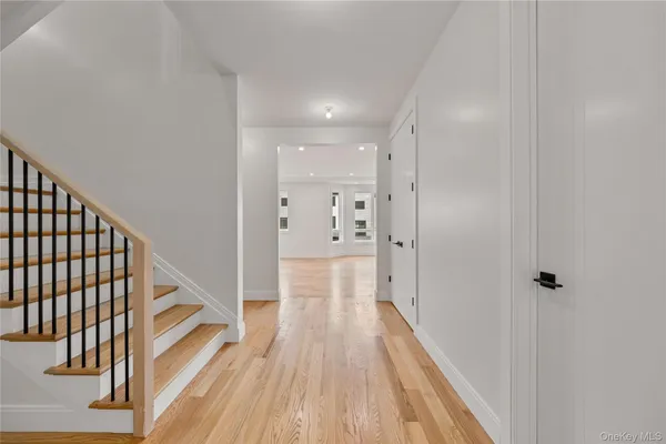 a view of a hallway with wooden floor and staircase