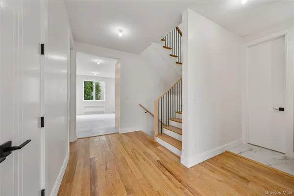 a view of a hallway with wooden floor and staircase