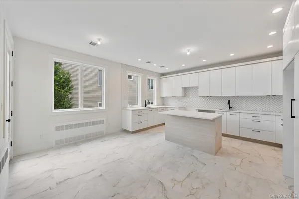 a large white kitchen with cabinets