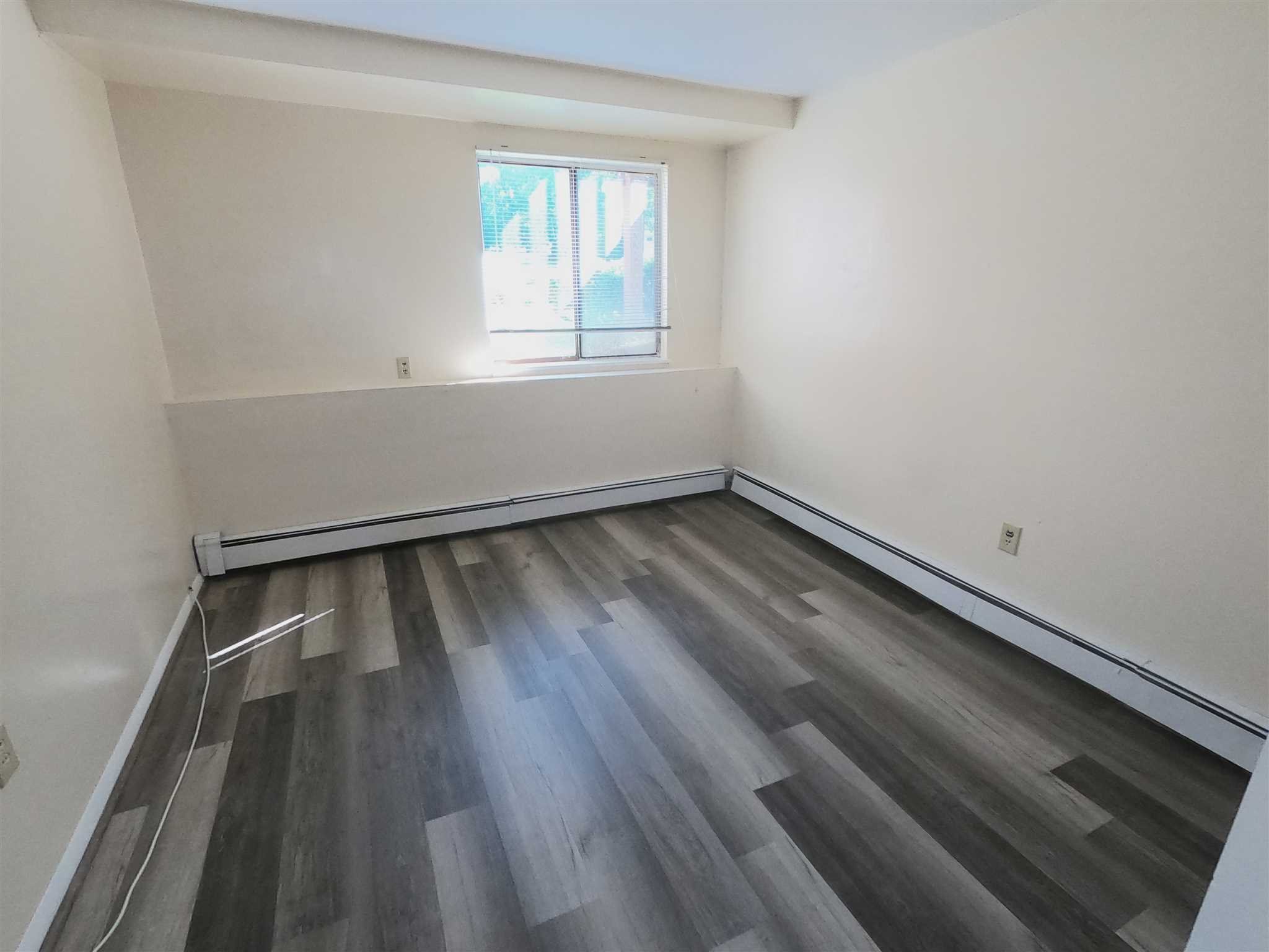 3 Hook Hyde Park, Unit 14A Poughkeepsie, NY 12601 - Photo 9 of 20 an empty room with wooden floor and windows