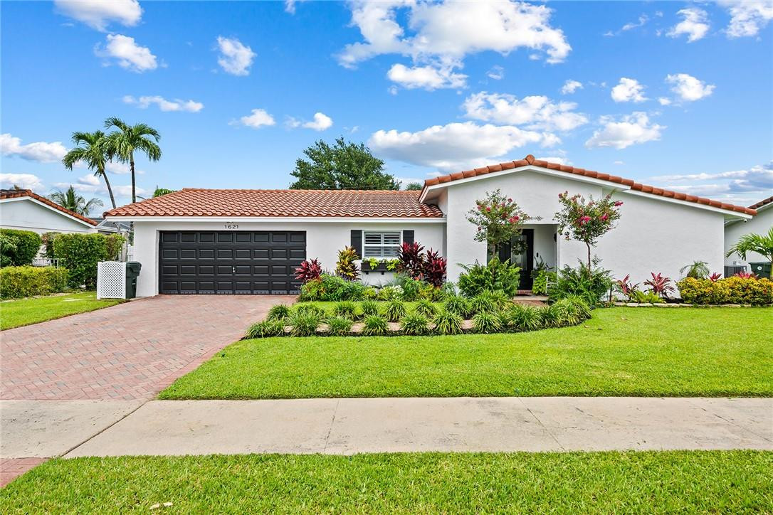 1621 Northwest 10th Street Boca Raton, FL 33486 - Photo 1 of 25 a front view of a house with a garden