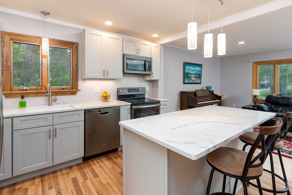 40 Riley Road Northborough, MA 01532 - Photo 9 of 24 a kitchen with stainless steel appliances kitchen island a table chairs sink and cabinets