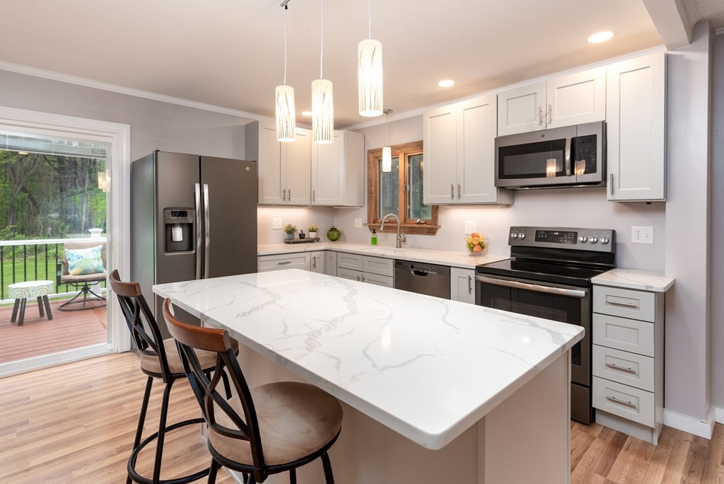 40 Riley Road Northborough, MA 01532 - Photo 10 of 24 a kitchen with stainless steel appliances a stove a refrigerator a sink a dining table and chairs with wooden floor