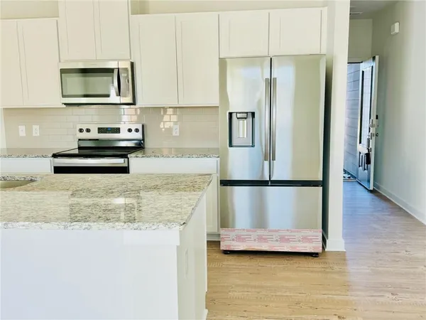 a kitchen with kitchen island a counter top space a refrigerator and a sink
