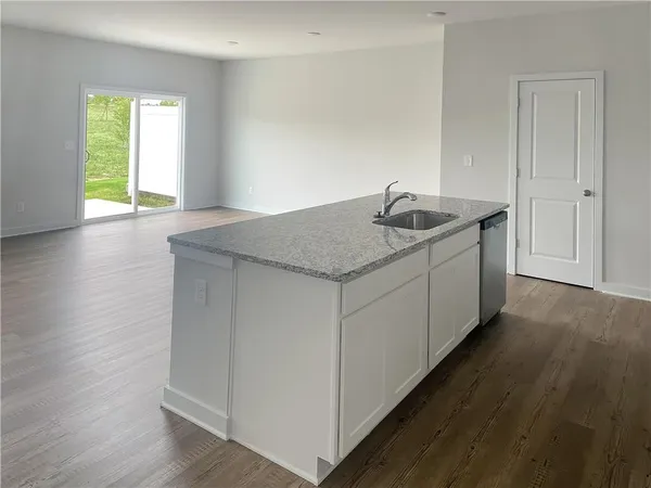 a kitchen with sink cabinets and wooden floor