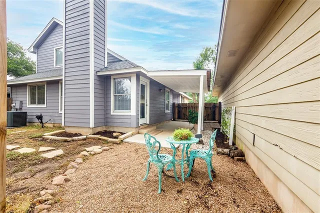 a patio with table and chairs and potted plants