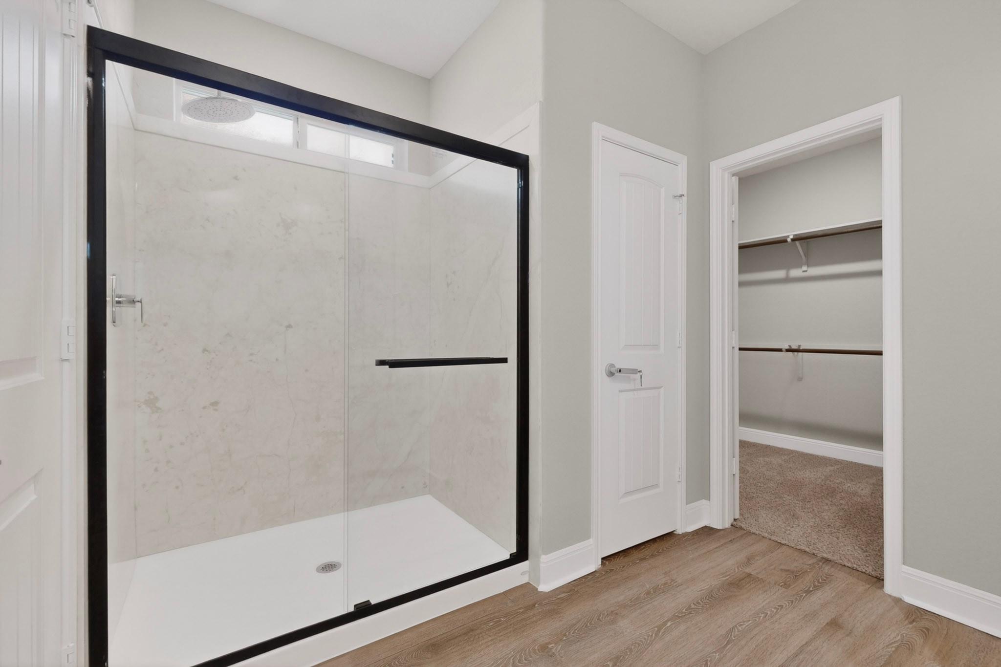 16809 Guido Cove Pflugerville, TX 78660 - Photo 20 of 40 Walk-in shower with black-framed glass enclosure, light-toned wall tile, and rain showerhead