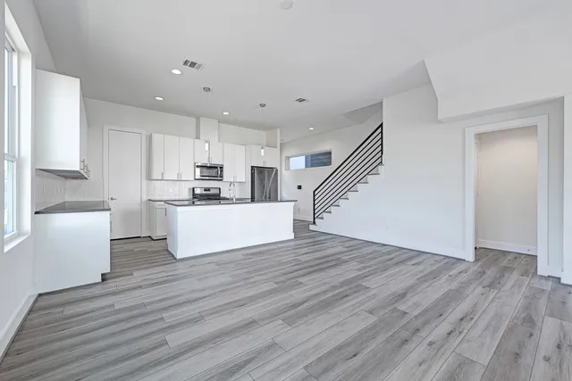 a view of a kitchen with wooden floor and electronic appliances