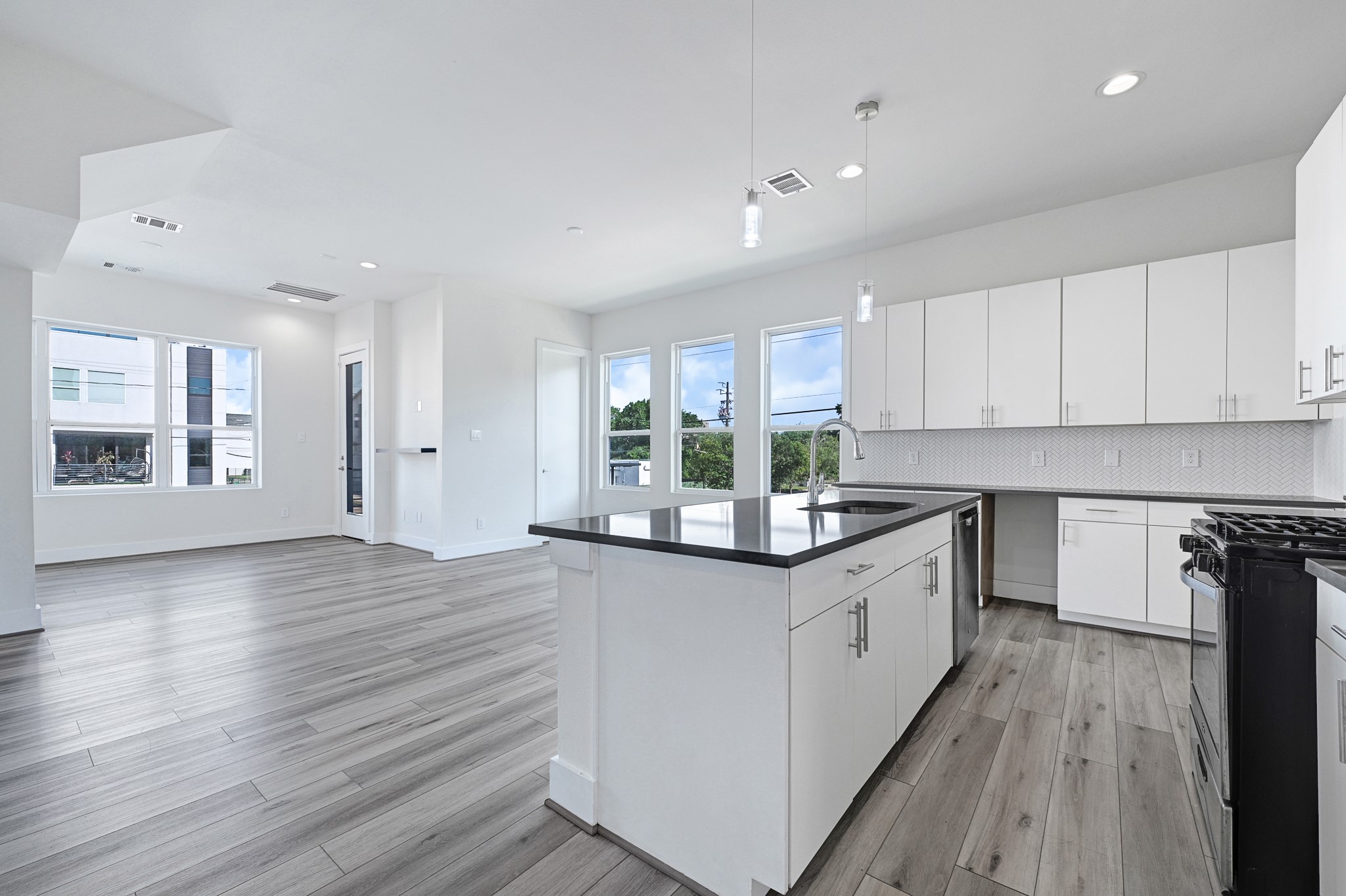 3313 Baer Street Houston, TX 77020 - Photo 9 of 26 a kitchen with stainless steel appliances granite countertop wooden floors and white cabinets