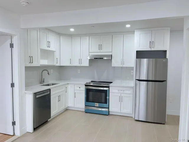 a kitchen with stainless steel appliances white cabinets and a refrigerator