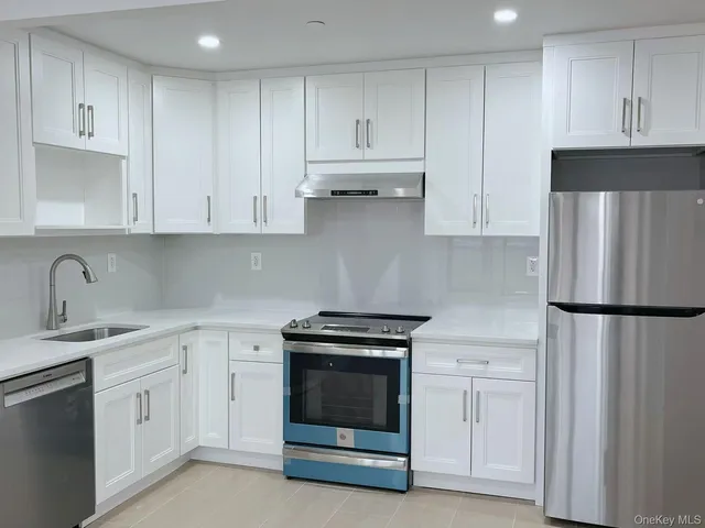 a kitchen with white cabinets and white appliances