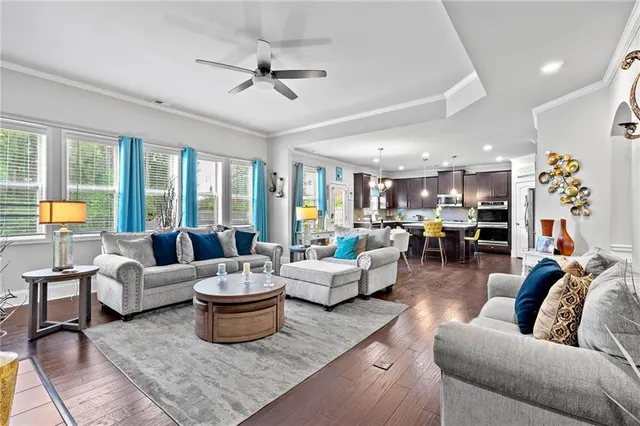 a living room with furniture kitchen view and a large window
