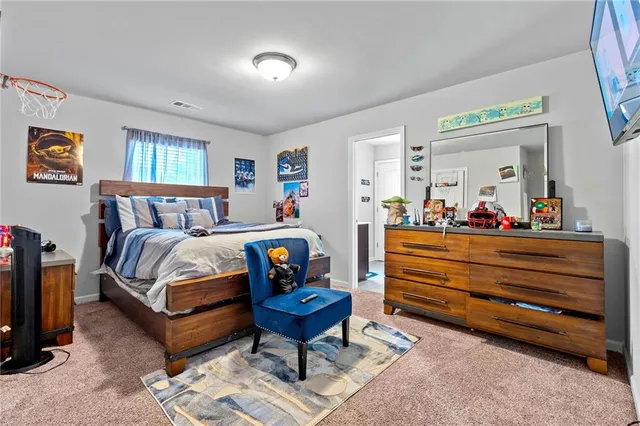 a bedroom with a bed a dresser and a window