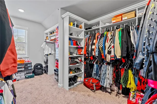 a view of walk in closet with clothes and shoes