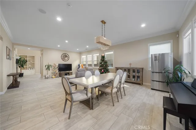 a view of a dining room and livingroom with furniture wooden floor a rug a potted plant and a chandelier