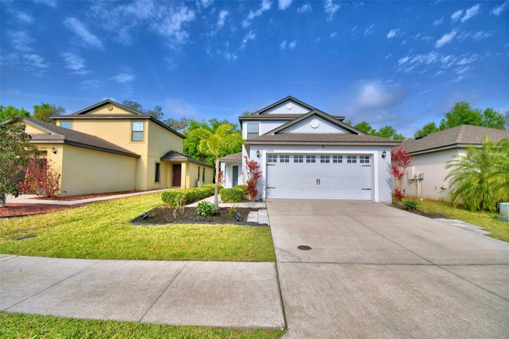 a front view of a house with a yard and garage