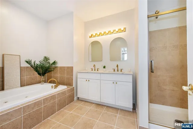 a bathroom with a tub sink and mirror