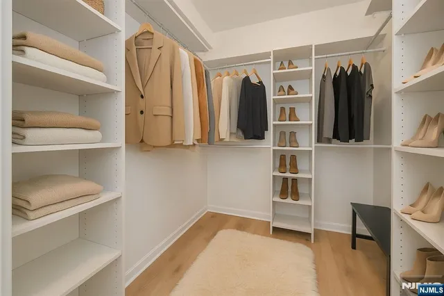 a view of walk in closet with clothes and shoes