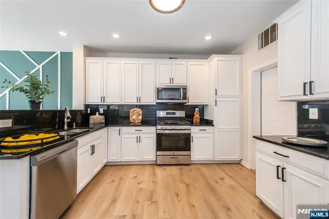 a kitchen with stainless steel appliances a stove a sink and a refrigerator