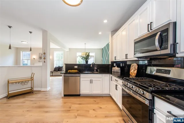 a kitchen with stainless steel appliances kitchen island granite countertop a stove and a sink