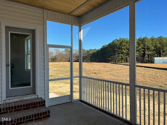 a view of a balcony with a floor to ceiling window and wooden floor